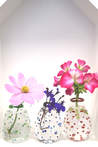 single flower in each of three vases on display